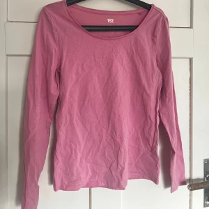 Rosa långärmad topp från 157 - Säljer en rosa långärmad topp från 157. Perfekt för en avslappnad stil. Toppen har en enkel design med rund halsringning.
