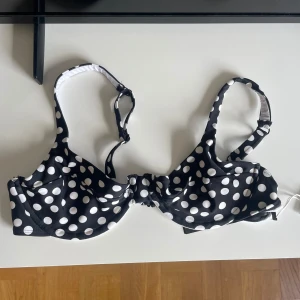 Svart och vit prickig bikiniöverdel - Snygg bikiniöverdel med breda axelband och bygel. Helt ny och aldrig använd! Justerbara axelband för bästa passform. Vid några frågor är det bara att skriva!!💞💞