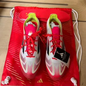 Adidas F50 elite fotbollsskor - Adidas F50 fotbollsskor i vitt med röda och svarta detaljer. Perfekta för spelare som vill ha både stil och prestanda. Kommer med påse och extra sulor, samt original boxen. Dem är för stora och oanvända. Pris kan diskuteras.
