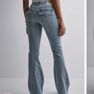 True religion jeans - Snygga blå bootcut jeans med låg midja och klassisk femficksdesign. Jeansen har en knappgylf och dekorativa sömmar på bakfickorna. Storlek 29, knappt använda. Från true religion 