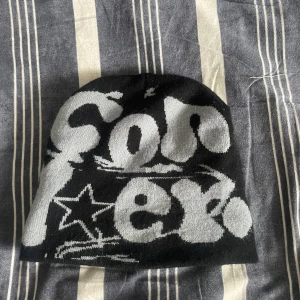 Y2k mössa - Säljer nu denna Snygga svart y2k mössa med grått tryck och stjärnmönster. 