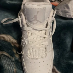 Vita Nike Air Jordans - Säljer ett par stilrena vita Nike Air Jordans. Skorna har en klassisk design med snörning och perforerade detaljer för extra ventilation. Perfekta för dig som vill ha en tidlös sneaker med ikonisk stil.