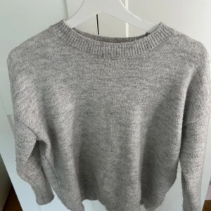 Grå stickad tröja från Gina Tricot - Säljer en grå stickad tröja från Gina Tricot då den nu är för liten för mig. Bra kvalitet och använd ett fåtals gånger!