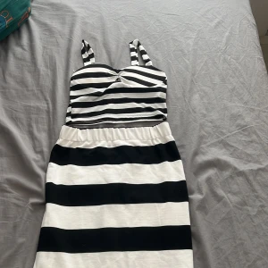 Set topp och kjol - Snygg randig klänning i svart och vit med axelband. Klänningen har en tight passform upptill och ärmlös      Topp är lite smutsig (bild 5)