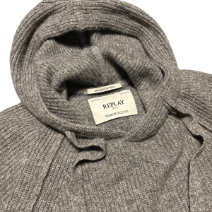 Grå stickad hoodie från Replay - Säljer en stilren grå stickad hoodie från Replay. Har använts, men ser fortfarande ny ut. Pyttelite knotter och armbågarna är lite nötta. Köptes för 2000kr och säljes för 800, priset kan diskuteras.