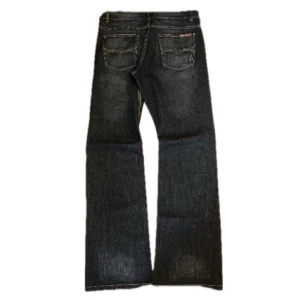 Flared jeans - Snygga mörk blåa jeansbyxor från med klassisk femficksdesign. Byxorna har en bootcut-stil och är perfekta för en avslappnad look. De har en diskret logga på bakfickan och är tillverkade i ett slitstarkt denimtyg.