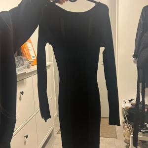 Svart ribbad klänning från divine  - Snygg svart ribbad klänning från HM i en elegant och stilren design. Klänningen har långa ärmar och en tight passform som framhäver figuren. Perfekt för en chic look!