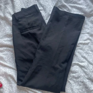 Svarta kostymbyxor från Bik Bok - Snygga svarta kostymbyxor från Bik Bok i klassisk design. Byxorna har en rak passform med diskreta fickor och hällor för bälte. Perfekta för en stilren look.