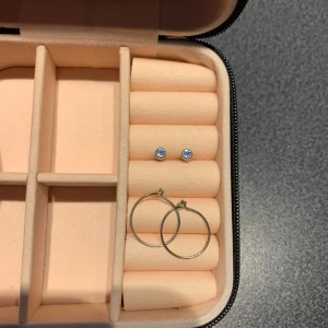 Två par örhängen - Ett par ringar och ett par läkörhängen i silver. Blåa stenar i läkörhängena.