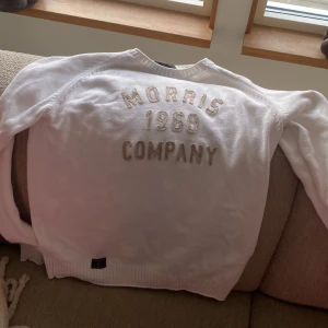 Vit tröja från Morris - Säljer en stilren vit tröja från Morris med texten 'Morris 1968 Company' broderad på framsidan. Tröjan har långa ärmar och en klassisk rund halsringning. Perfekt för en avslappnad och snygg look.