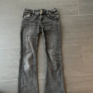 Grå bootcut jeans - Snygga grå bootcut jeans med dubbla knappar i midjan och klassiska femficksdetaljer. Jeansen är nedsprättade av mig för att få dem längre🩷