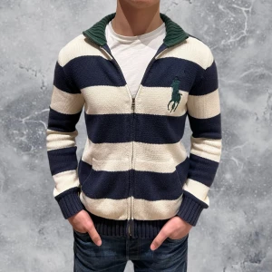 Ralph Lauren Full Zip Tröja Vit - •Ralph Lauren Full-Zip Tröja vit/blå/grön. Skick: 8/10, Inga skador! Storlek: 14/16 år, 160-180 cm = S~. Modell: 173 cm, 65 kg. Sitter bra på modellen på bild! Authentic: ✅. Hör av dig vid frågor eller funderingar, mvh Hessler’s;)