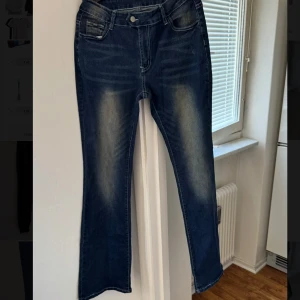 Blå blekta jeans  - Snygga högmidjade blå jeans med en klassisk look och slitningar på låren. De har en normal passform och är perfekta för en avslappnad stil. Jeansen har fickor fram och bak samt en knapp och dragkedja i gylfen.
