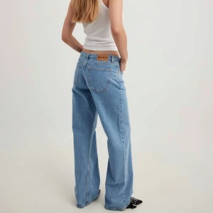 Blå jeansbyxor från NA-KD - Trendiga jeans från NA-KD! Är i nyskick och säljer då de inte kommer till användning. Nypris 699, mitt pris 450kr! Säljer även i svart❣️