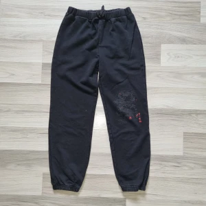Svarta mjukisbyxor med drakmotiv från Shein - Säljer ett par svarta mjukisbyxor från Shein med ett coolt drakmotiv på benet. Byxorna har elastisk midja och muddar vid bensluten för en bekväm passform. Perfekta för en avslappnad stil.