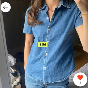 Blå jeansskjorta - Snygg blå jeansskjorta med korta ärmar och knappar framtill.