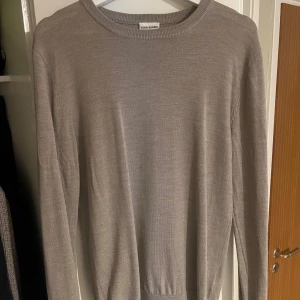 Beige stickad tröja John Henric - Snygg beige stickad tröja från John Henric. Tröjan är i 100% merinoull. Den enda defekten är det lilla hålet.