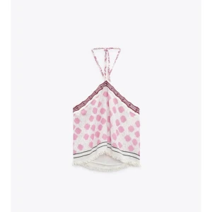 Rosa prickig linnetopp med spets - Supersöt linnetopp med rosa prickar på vit botten, tunna axelband och spetsdetalj i vinrött längs v-ringningen. Toppen har även en dekorativ kant nertill och är perfekt för varma dagar. Använd en gång men passar tyvärr inte mig! 