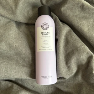 Texture Spray från Maria Nila - Ljuslila texturspray från Maria Nila i en stilren flaska med svart lock. Sprayen ger volym och textur till håret och är 100% vegansk. Innehåller 250 ml och har en modern, minimalistisk design.