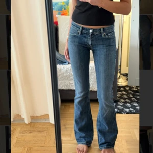 Levis 527 bootcut jeans blå - Säljer ett par klassiska Levis 527 jeans i blå denim med bootcut passform. Jeansen har låg midja, fem fickor och snygga slitningar för en cool look. Perfekta för dig som gillar en tidlös och avslappnad stil.