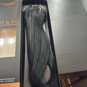 Poze Clip on löshår svart 40 - Clip & Go löshår från Poze i en djupsvart nyans. Snyggt, rakt och glansigt äkta hår med clip on i 7 delar. 40cm 100 gram aldrig använt. Nypris 950