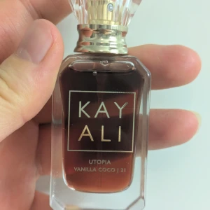 Kayali Utopia Vanilla Coco 21 EdP 10ml - Kayali Utopia Vanilla Coco 21 Intense är en eau de parfum i 10 ml flaska. Doften har noter av päron, jasmin, kokos, sandelträ och bourbonvanilj. Flaskan är genomskinlig med guldiga detaljer och en elegant, kristalliknande kork. Provat ett sprut.