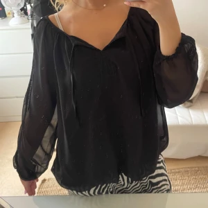 Boho blus svart - Super söt blus med genomskinligt tyg på armarna samt över det vanliga tyget. Super söt men kommer tyvärr ej till andledning.