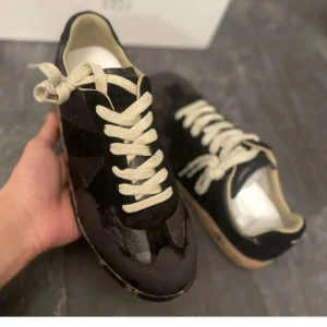 Maison Margiela skor - Säljer nu mina Maison Marcella’s skor som är svarta. Bekvämaste skorna jag någonsin har haft. Allt OG följer med. Bilderna från början är när de var ny men har haft dem nu i ett halvår men är fortfarande i bra skick.sulorna är smutsiga men det är inget man ser Bara lite smutsiga men det går att tvätta. Köpta för 3600 kr. Designen på skon är väldigt unik och det är inte enkelt att få tag på dessa skor.senad är de limmade längst fram på skorna för flärpen lossnade lite men det är inget som syns.