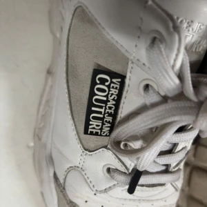 Vita sneakers  - Chunky vita sneakers, Skorna har tydlig logga på sidan, snörning och en rejäl sula som ger en cool streetkänsla. Perfekta för dig som vill sticka ut med stil.