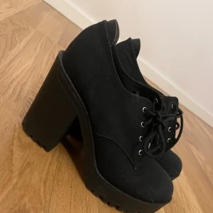 klackskor  - Svarta klackskor från H&M Divided med grov plattform och hög klack. Skorna har snörning framtill och är tillverkade i textilmaterial. Perfekta för dig som gillar en edgy och trendig stil. MYCKET BEKVÄMA