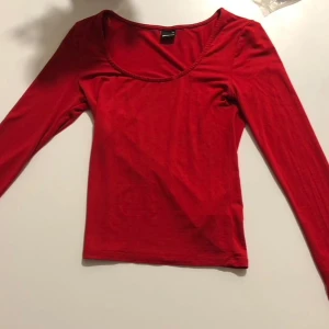 Röd långärmad topp Gina Tricot XS - Enkel och snygg röd långärmad topp från Gina Tricot i storlek XS. Modellen har rundad urringning och är figurnära i passformen. Perfekt att styla med jeans eller kjol för en clean look. Mjuk och stretchig bomullskänsla.
