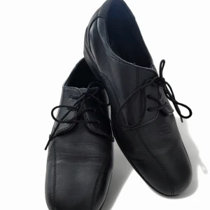 Svarta läder skor från Dr Keller - Klassiska svarta skor från Dr Keller i mjukt läder skinn med snörning framtill. Skorna har en rund tå och diskreta sömdetaljer som ger en stilren look. Perfekta för dig som gillar enkel och tidlös stil. Storlek 38, Klackhöjd 4.5 cm