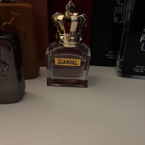 Scandal Jean Paul Gaultier EdT 50ml - Scandal från Jean Paul Gaultier är en eau de toilette för herr i en lyxig glasflaska med guldig krona som lock. Flaskan rymmer 50 ml (se mängd enligt bild)och kommer i en mörkröd ask med guld- och silverdetaljer. BYTEN KAN VARA INTRESSANT!