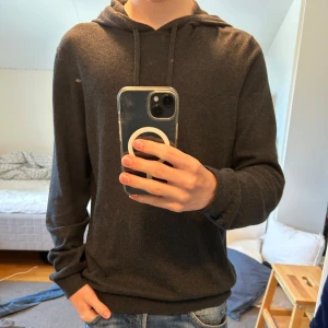 Mörkgrå hoodie från Ragman i kashmir - Mörkgrå hoodie från Ragman i en lyxig mix av bomull och kashmir. Fint skick. Säljer pga att den är för stor för mig.