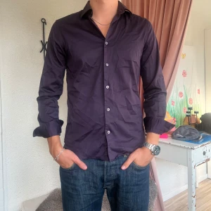 Mörklila skjorta - Säljer denna mörklila skjorta. Är i storlek S och sitter därmed tight på mig som vanligtvis är en M/L.