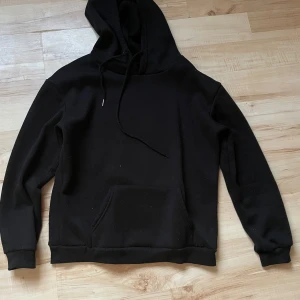 Svart hoodie från SHEIN - Säljer en stilren svart hoodie från SHEIN i storlek S. Den är tillverkad av 95% polyester och 5% elastan, vilket ger en skön och stretchig passform. Hoodien har en klassisk design med känguruficka och justerbar huva.