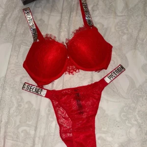 Röd spets-bh och trosa från Victoria’s Secret  - Snygg röd spets-bh och matchande trosa med glittriga axelband och midjeband. Setet har en lyxig känsla med detaljer i spets och paljetter på banden. Bh-n är i storlek 75B