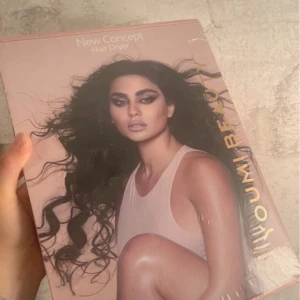  Hårtork från Youmi Beauty - Upptäck New Concept hårfön från Youmi Beauty med en elegant vit design och roségulddetaljer. Den har flera munstycken för olika stylingbehov och en innovativ motor för snabb torkning. Perfekt för att skapa volym och glans i håret. En stilren och funktionell hårfön för alla hårtyper.