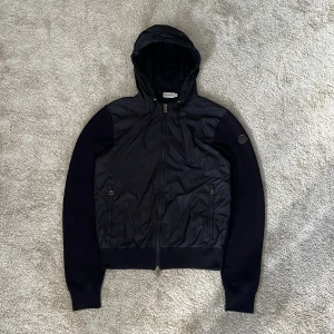 Moncler Cardigan - Hej! Säljer denna riktigt feta black label Moncler hooded cardigan i färgen Navy! Riktigt fint stickad och fin utan defekter förutom att det är lite slitet längst ut vid muddarna (bild 4). Storleken är Medium men sitter mera som en Small! nypris ~12000kr! Självklart äkta vilket jag garanterar och står för! 🙌skriv vid minsta intresse 😁Mvh DC 🔹
