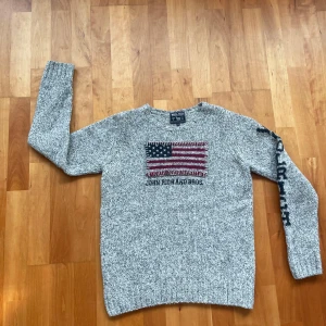 Grå stickad tröja från Woolrich - LÄS BESKRIVNINGEN!!! Snygg grå stickad tröja från Woolrich med amerikansk flagga och texten 'John Rich and Bros' på framsidan. Tröjan har långa ärmar med textdetalj på ena ärmen. Perfekt för kyliga dagar på vintern! Modellen på bilden är ungefär 166cm, skulle säga att tröjan passar någon som är mellan 160-168cm lång. Pris kan diskuteras vid snabb affär!!!