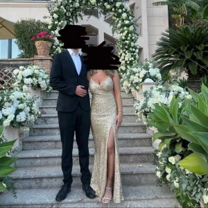 Glittrig guldklänning med slits - Säljer nu min superfina guld klänning😍klänningen har slits fram och är i storlek 36, jag är 163cm så längden på klänningen är bra. Den är endast använd 1 gång under ett bröllop så är i mycket fint nyskick 💗hör av er om ni vill ha fler bilder osv. 1500 eller bud 💗