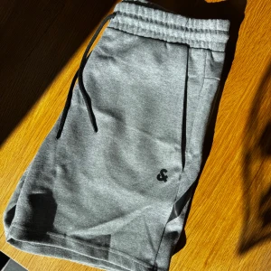 Grå shorts med snörning - Grå mjukisshorts från Jack and Jones. Finns även i ljusare grå med prislapp. Rensar ur min garderob från en hel del oanvända kläder🌼 Om du ser något mer i min profil som du gillar så skickar jag med det till dig också!😊 Fler kläder kommer! 