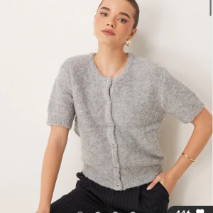 Fin grå kofta med korta ärmar - Säljer en mysig grå kofta med korta ärmar och knappar framtill. Perfekt för en stilren look. Endast använd ett fåtal gånger så den är i nyskick. Säljer då den inte kommer till användning.🤍