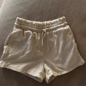 Vita shorts med resårmidja - Säljer ett par vita mjukis shorts. Midjan går att vika ner för lågmidja.