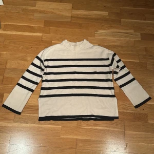 Randig tröja från Vero Moda - Säljer en snygg randig tröja från Vero Moda i beige och svart. Tröjan har långa ärmar och en bekväm passform. Perfekt för en stilren look.