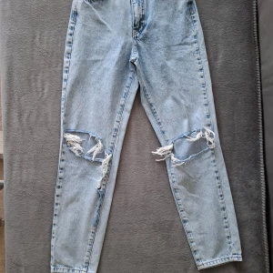 Ljusa jeans med slitningar från Perfect Jeans - Snygga ljusblå jeans med coola slitningar på knäna från Perfect Jeans. De har en klassisk femficksdesign och en bekväm passform. Perfekta för en avslappnad stil med en trendig edge.