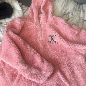 Rosa teddyjacka från Juicy Couture - Mysig rosa teddyjacka från Juicy Couture med huva och dragkedja. Perfekt för att hålla sig varm och bekväm. Jackan har en broderad logga på bröstet och är en del av Juicy Couture Sport-kollektionen. Skriv för frågor❤️
