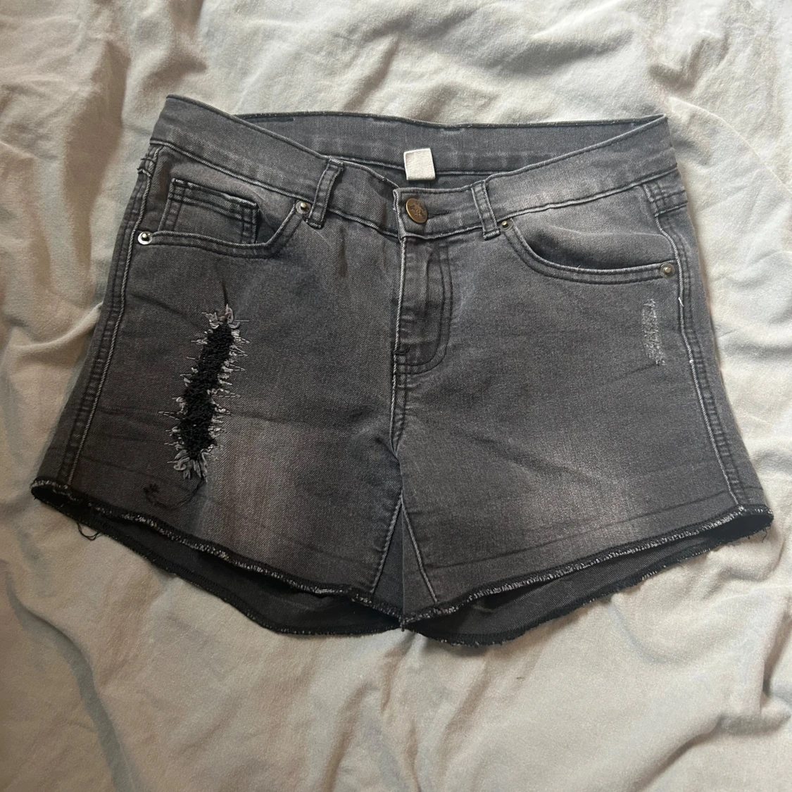Grå jeansshorts med slitningar