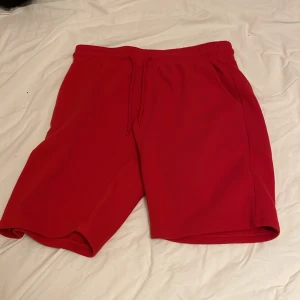 Röda shorts från FSBN med snörning - Riktigt snygga och helt nya, oandvända  röda shorts från FSBN i mjukt material. De har elastisk midja med snörning, två sidofickor och en bakficka. Perfekta för sommardagar eller chill hemma. Klassisk passform och stilren look.