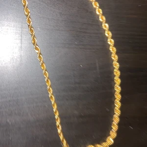 Guldfärgat tvinnat halsband - Snyggt guldfärgat halsband med tvinnad kedja som ger en cool och trendig look. Perfekt för att lyfta vilken outfit som helst med lite extra bling. Passar dig som gillar statement-smycken och vill sticka ut. Skriv för mer information 